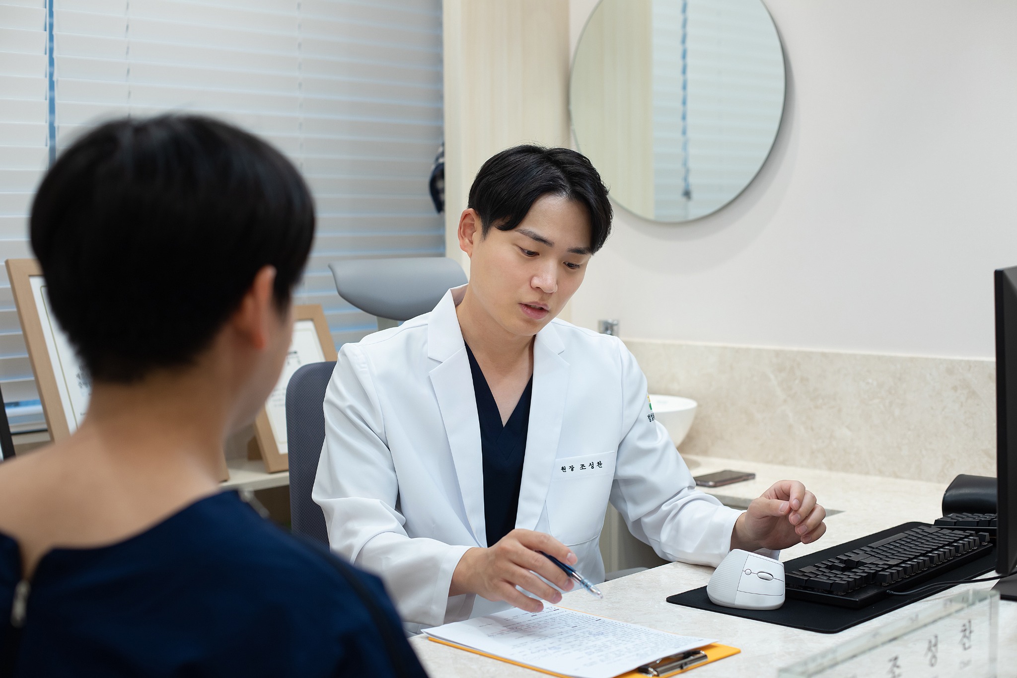 환자와 마주 앉아 자료를 확인하며 상담하는 조성찬 원장