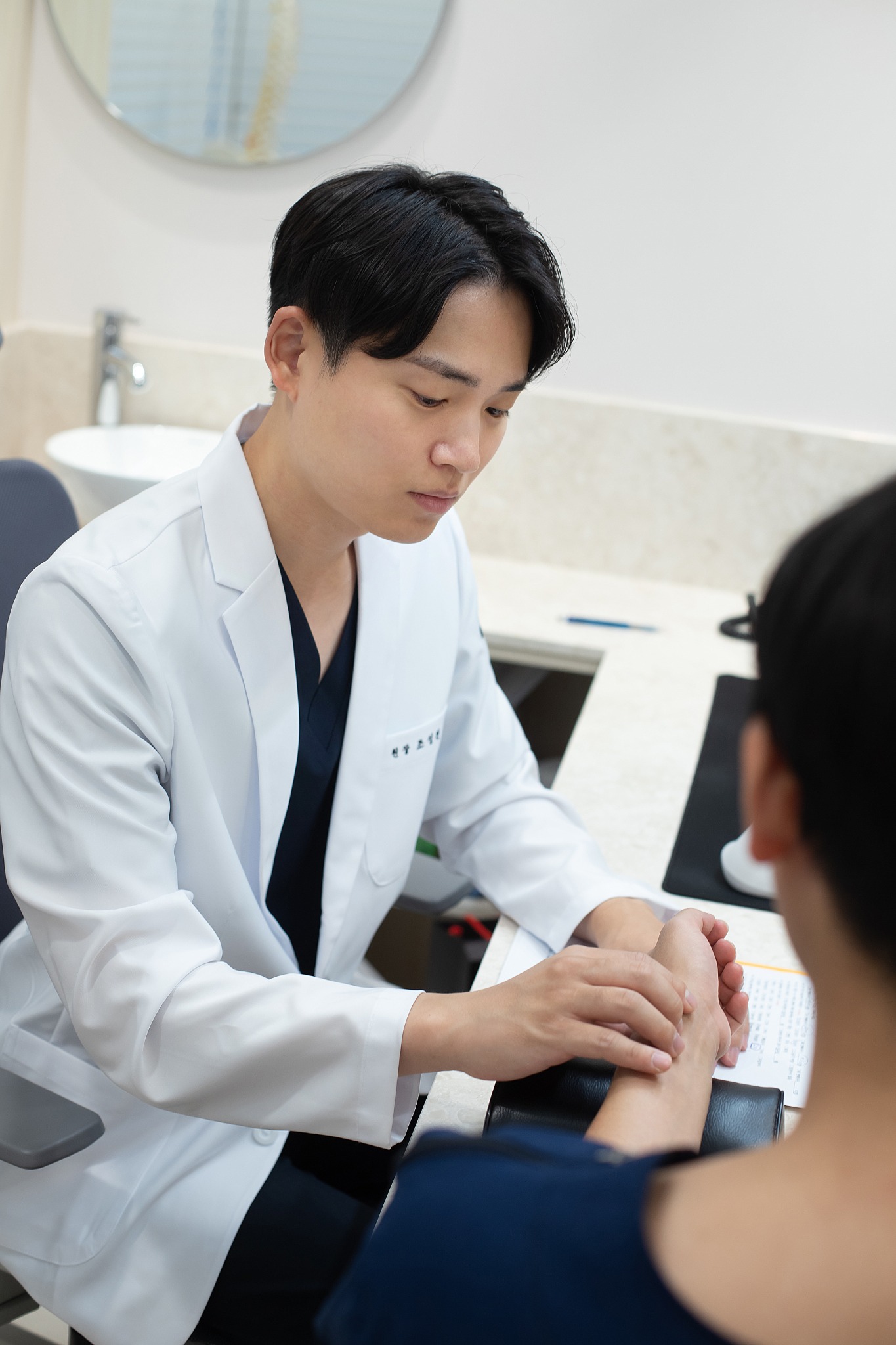 환자의 손목을 살피며 맥진하는 조성찬 원장